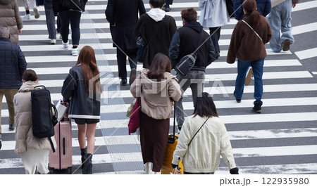 ハイアングルで撮影した冬の朝の都市の交差点で横断歩道を渡る人々の姿 122935980