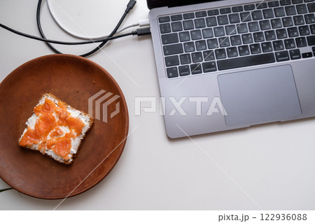 Breakfast with Smoked Salmon on Bread Next to Laptop 122936088