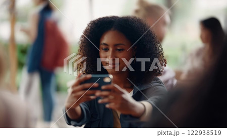 Young woman taking photos with smartphone in a public space 122938519