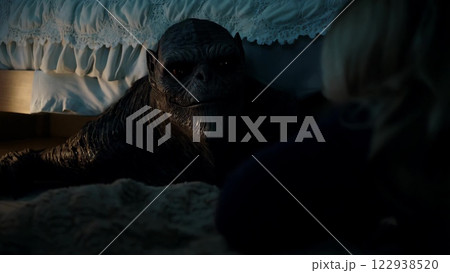 Curious alien observing a woman under the bed 122938520
