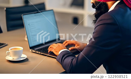 Sikh businessman typing on laptop in modern office 122938521