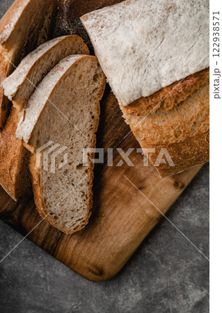 Sliced loaf of bread on cutting board. Top view. 122938571
