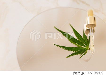 Mock up bottle cosmetic product and pipette with cannabis leaves on white glossy background Mock up bottle cosmetic product and pipette with cannabis leaves on white glossy background 122939997