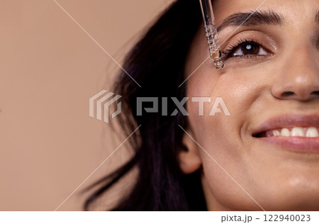 Close-up of charming woman holding pipette with regenerating serum with hyaluronic acid Close-up of charming woman holding pipette with regenerating serum with hyaluronic acid 122940023