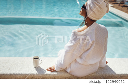 Young pretty woman in a white bathrobe holds a cup of coffee. Young pretty woman in a white bathrobe holds a cup of coffee. 122940032