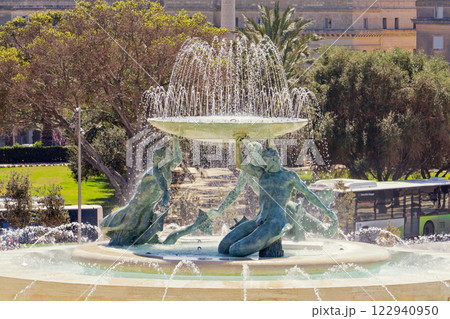 Iconic Triton fountain in Valletta reveals dynamic flow of swirling water, fountain capturing intricate bronze sculpture, fountain symbolizing Maltese heritage: Valletta, Malta - 06.04.2019 122940950