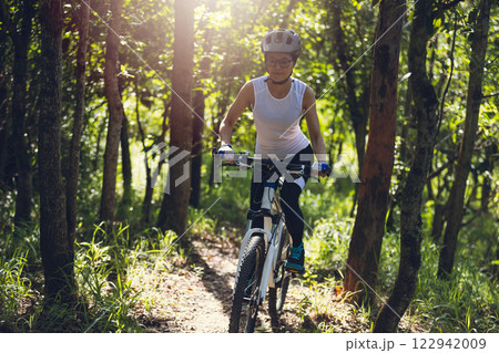 Mountain biking on summer forest trail 122942009