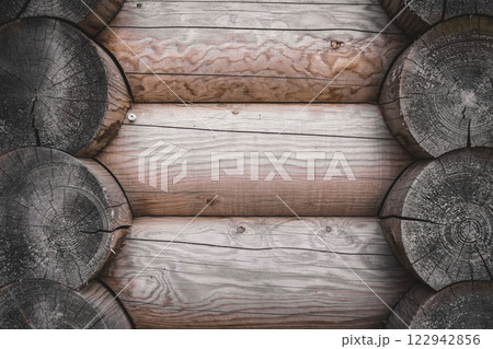 texture of a wooden wall made of logs, light wood texture. wooden house.  122942856