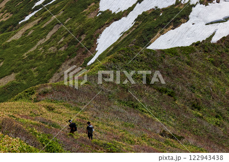 谷川連峰・万太郎山から見る残雪の上越国境稜線を行く登山者 122943438