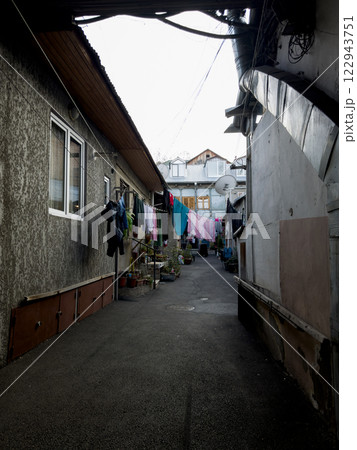 Cozy courtyard with clean laundry drying on warm day Cozy courtyard with clean laundry drying on warm day 122943751