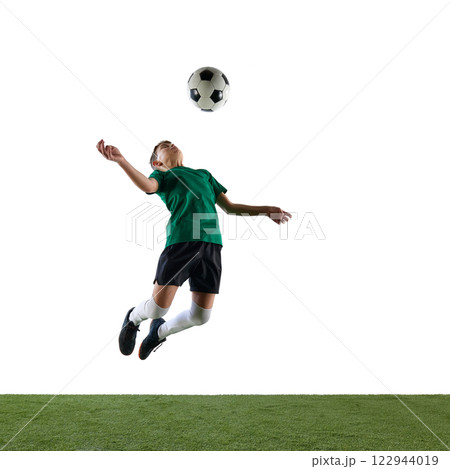 Dynamic image of competitive boy, soccer player in motion, training, kicking ball with chest against white studio background. Dynamic image of competitive boy, soccer player in motion, training, kicking ball with chest against white studio background. 122944019