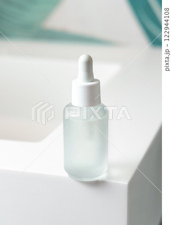 Clear glass dropper bottle on washbasin in green tropical bathroom close up, cosmetic mockup 122944108