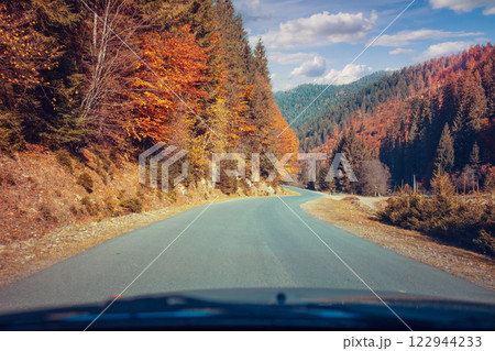 Driving a car along a mountain winding road. Empty road. View from a car to the autumn mountain landscape 122944233