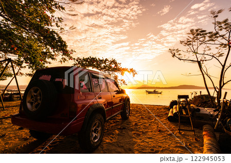 24 January 2025 Red 4x4 car Suzuki Vitara 1993 on the rawai beach Tropical sea view Beautiful nature sea view at sunrise in Phuket Thailand 122945053