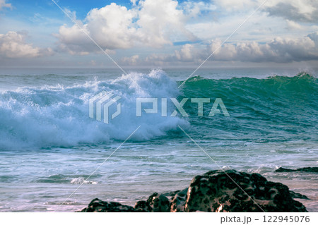 The wave rolls over the rocky shore The wave rolls over the rocky shore 122945076