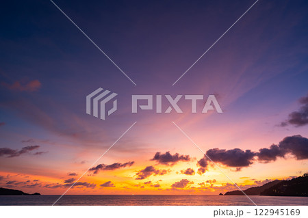 Amazing colorful clouds in sunset or sunrise sky over sea nature landscape background Amazing colorful clouds in sunset or sunrise sky over sea nature landscape background 122945169