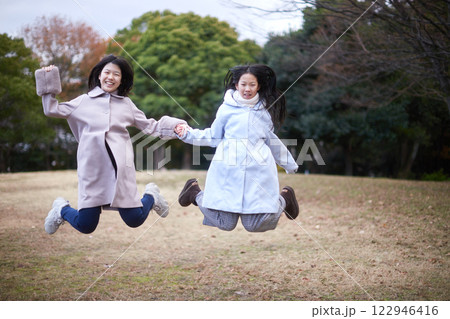冬の朝の公園で元気で楽しく遊んでいる子供姉妹の姿 冬の朝の公園で元気で楽しく遊んでいる子供姉妹の姿 122946416