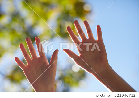 秋の公園の緑の森と青空と小学生の女の子の手の様子 秋の公園の緑の森と青空と小学生の女の子の手の様子 122946712