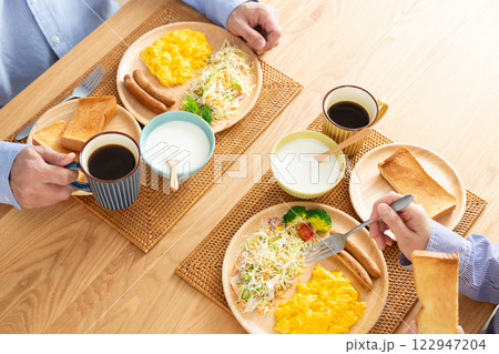 洋食の朝食を食べるミドル夫婦 122947204