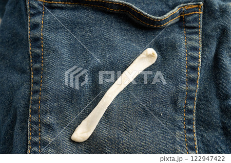 Dirty chewing gum stain removal on cloth jean accident to wash with washing powder, cleaning housework. 122947422