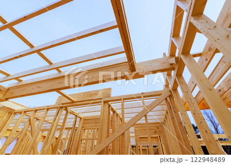Constructing wooden frame structure with beams trusses in residential area Constructing wooden frame structure with beams trusses in residential area 122948489