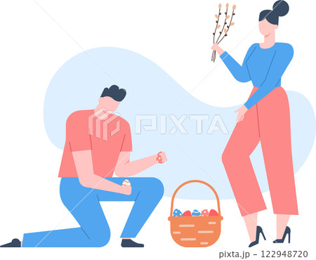 Man kneeling and holding easter eggs next to a basket full of colorful eggs and woman holding pussy willow branches, preparing for easter celebrations 122948720