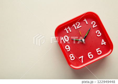 Red wall clock on grey background. Space for text 122949448