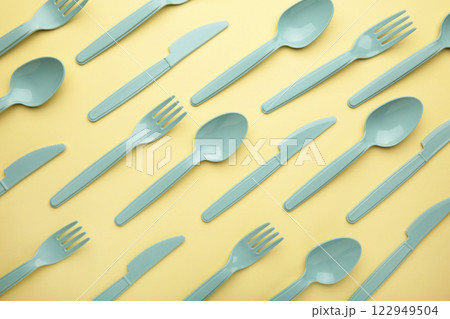 Flay lay photo of blue plastic disposable forks, spoons and knives. Creative top view pattern. 122949504