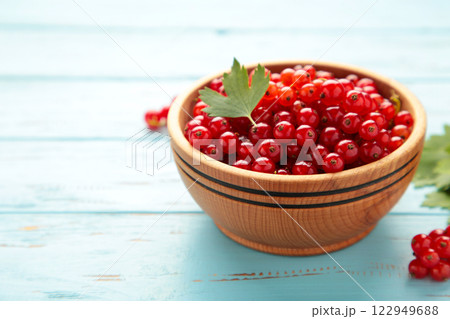 Bowl with ripe red currant on blue wooden background. Top view. Bowl with ripe red currant on blue wooden background. Top view. 122949688