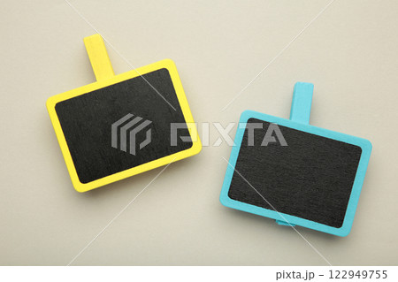 Blank wooden chalk plate on clothespins on grey background Blank wooden chalk plate on clothespins on grey background 122949755