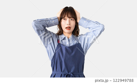 頭を抱えて悩むエプロン姿の女性 頭を抱えて悩むエプロン姿の女性 122949788