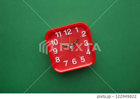 Red wall clock on green background. Space for text Red wall clock on green background. Space for text 122949822
