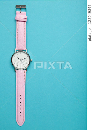 Pink wrist watches on blue background with copy space. Vertical photo 122949845