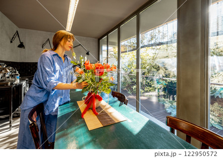 Woman Arranging Flowers in a Modern Kitchen 122950572