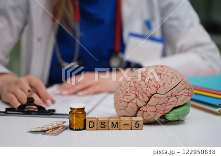 A desk of a Mental Health Professional with a Brain Model and DSM5 Diagnostic Manual A desk of a Mental Health Professional with a Brain Model and DSM5 Diagnostic Manual 122950838