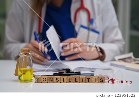 A healthcare professional diligently examining and evaluating a tonsillitis case for treatment 122951322