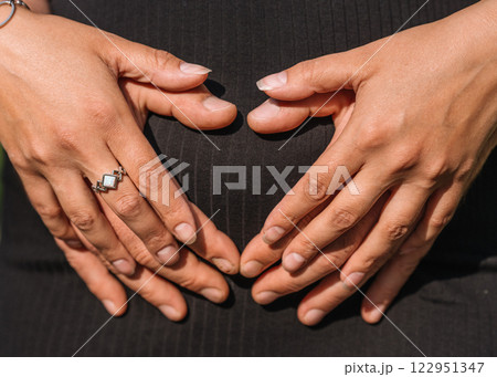 belly of pregnant woman in black dress close-up with mom and dad's hands on her belly. High quality photo belly of pregnant woman in black dress close-up with mom and dad's hands on her belly. High quality photo 122951347