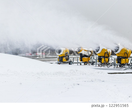 Shot of the industrial machinery so called snow gun or snow cannon that produces artificial snow in action. Shot of the industrial machinery so called snow gun or snow cannon that produces artificial snow in action. 122951565