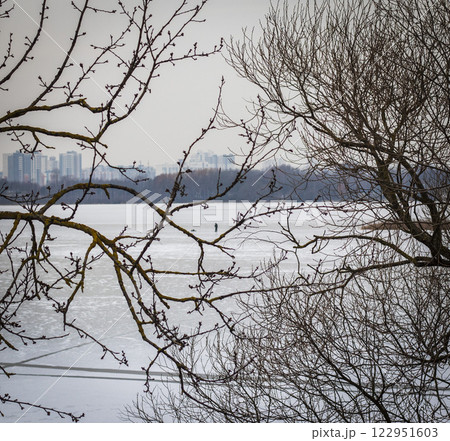 Concept shot of the man fishing on the frozen lake 122951603