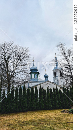 White vintage church behind the trees 122952059