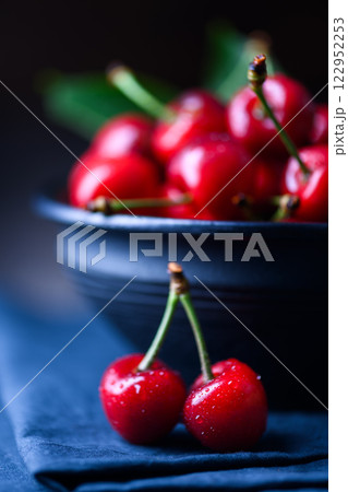 Close-up of ripe fresh red cherries on a blue tablecloth Close-up of ripe fresh red cherries on a blue tablecloth 122952253
