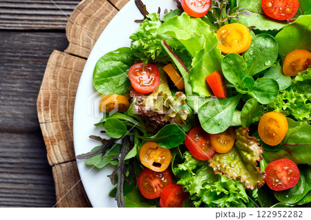 Mix of fresh organic juicy salad greens with red and yellow cherry tomatoes Mix of fresh organic juicy salad greens with red and yellow cherry tomatoes 122952282