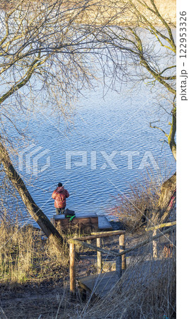 Shot of the man fishing on the winter river 122953326