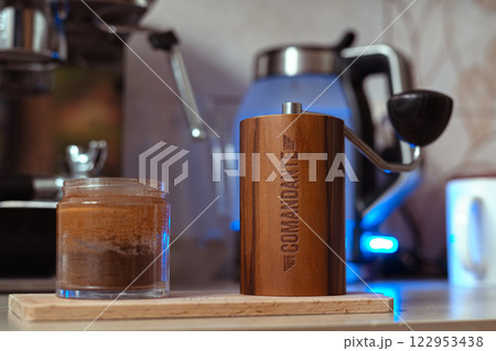 Poland, Wroclaw, 8 January 2025. Hand Coffee Grinder Comandante c40 Nitro Liquid Amber on the kitchen wooden cutting board. Close up, detailed.  122953438