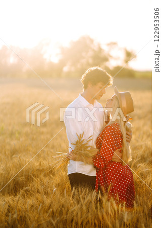 Young happy couple hugging on a wheat field, on the sunset. Enjoying time together. Young happy couple hugging on a wheat field, on the sunset. Enjoying time together. 122953506