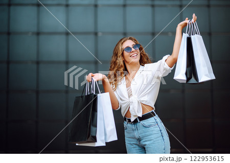 Woman in shopping. Woman with shopping bags walking around city after shopping. Lifestyle concept. Woman in shopping. Woman with shopping bags walking around city after shopping. Lifestyle concept. 122953615