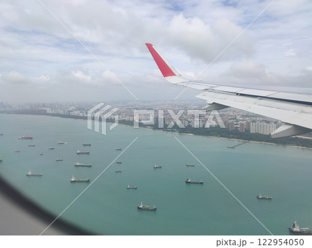 View of Singapore from a landing airplane out the window at cloudy day View of Singapore from a landing airplane out the window at cloudy day 122954050