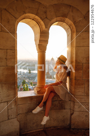 Young female tourist looking at panoramic view of city at sunset. Lifestyle, travel, active life. Young female tourist looking at panoramic view of city at sunset. Lifestyle, travel, active life. 122954676