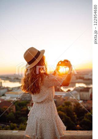 Travel in Europe. Young woman enjoys sunrise. The concept of travel, tourism, vacation and freedom. 122954680