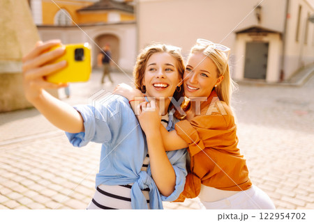 Young friends having fun and take selfie on the phone together. Entertainment, youth concept. Young friends having fun and take selfie on the phone together. Entertainment, youth concept. 122954702